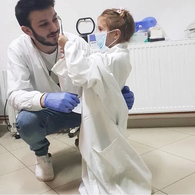 Doktor sa devojčicom u belom mantilu